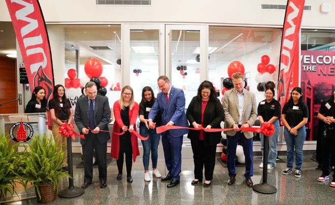 Six people cutting a ribbon