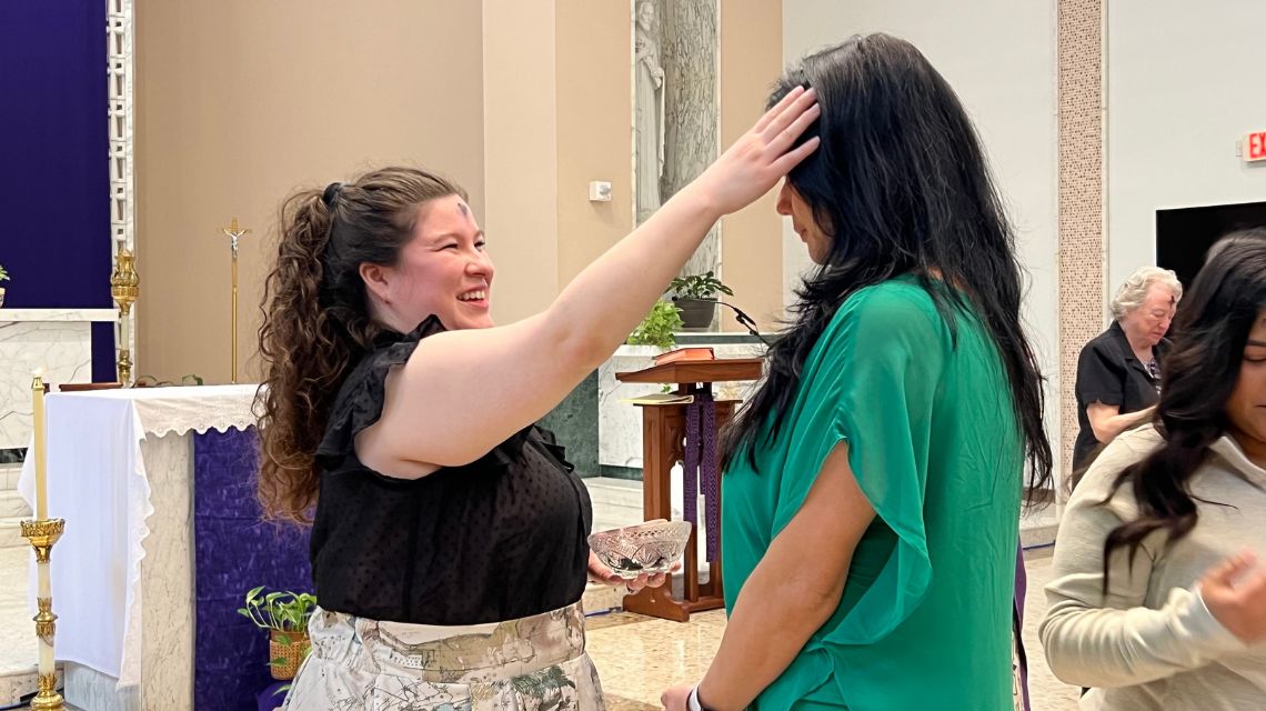 Woman wearing green shirt receives ashes