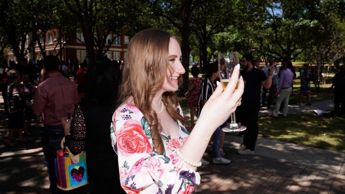 Student with curly hair holding glass