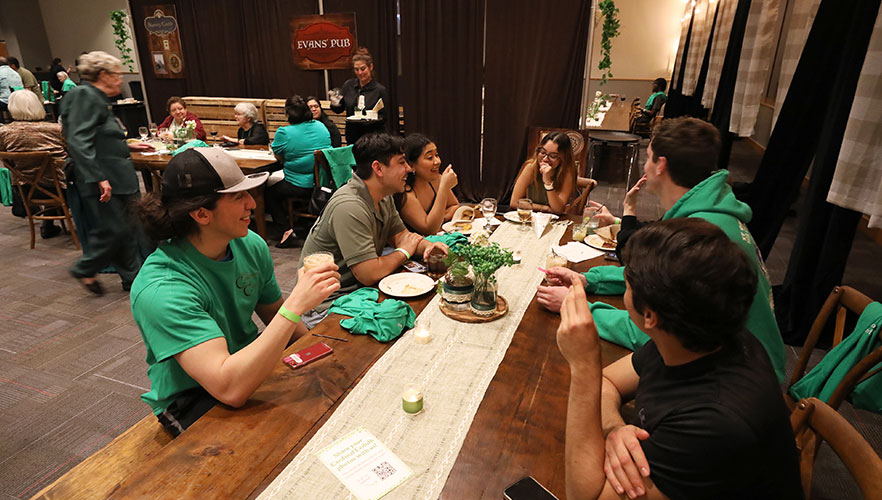 Attendees eating and talking at table.