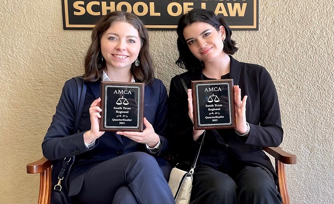 Holland and Goeke sitting with awards