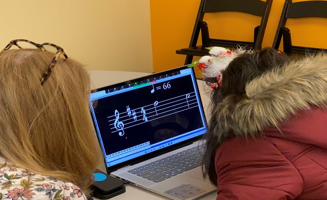 Young girl reading music using vision equipment.