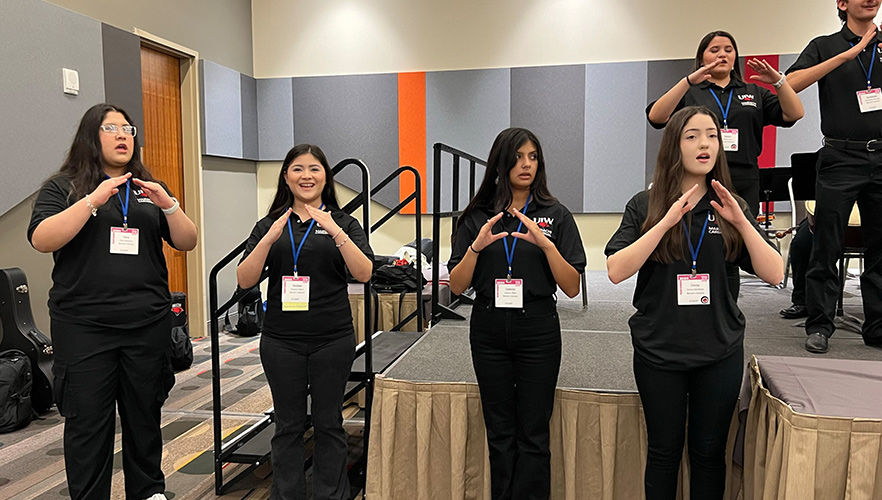 4 students participating in event smiling