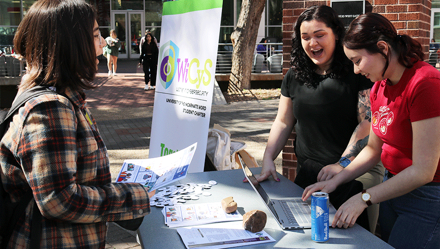 WiCyS members working event table.