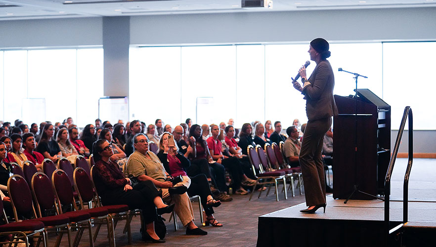 presenter on stage with audience
