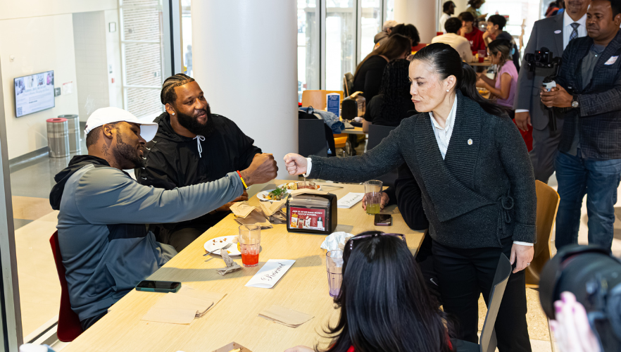 Mayor Gina Ortiz Jones fist bumping a UIW student