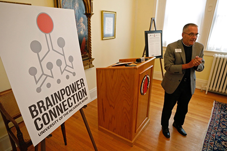 New Brainpower Connection Logo and Brother John Paige standing next to it