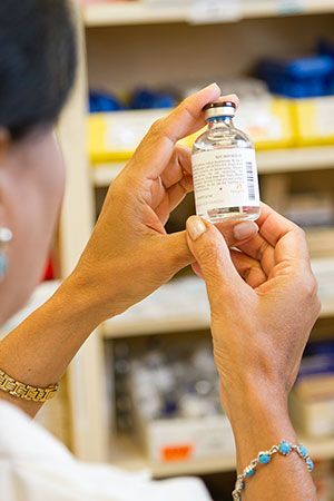 A woman looking at a bottle of medicine close-up
