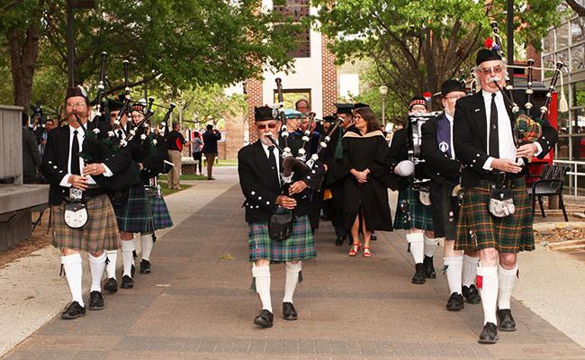 The San Antonio Pipes and Drums playing bagpipes in the procession