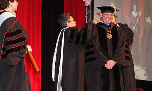 Charlie Lutz and Sr. Teresa Maya present the Presidential Medallion to Dr. Evans