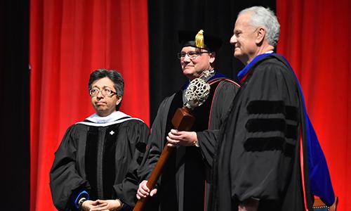 Chairman Charlie Lutz and Sr. Teresa Maya CCVI present University Mace to Dr. Evans