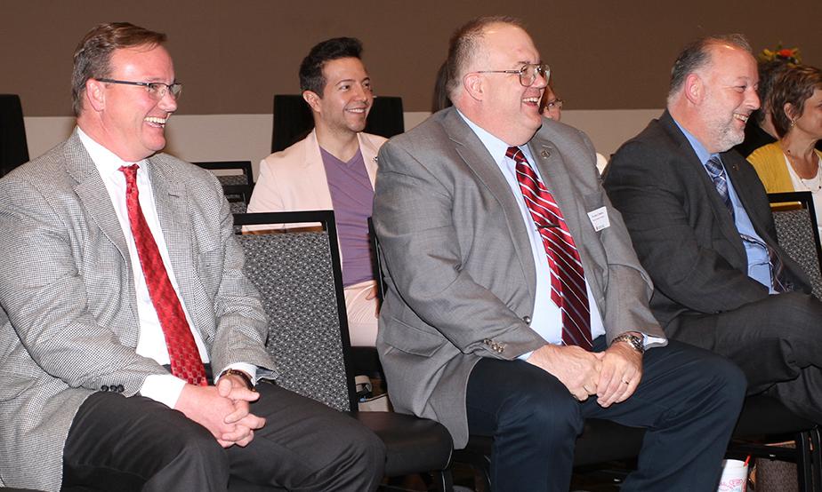 Dr. Evans listening to a speech with UIW Professors