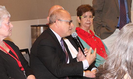 Man speaks among people with a microphone