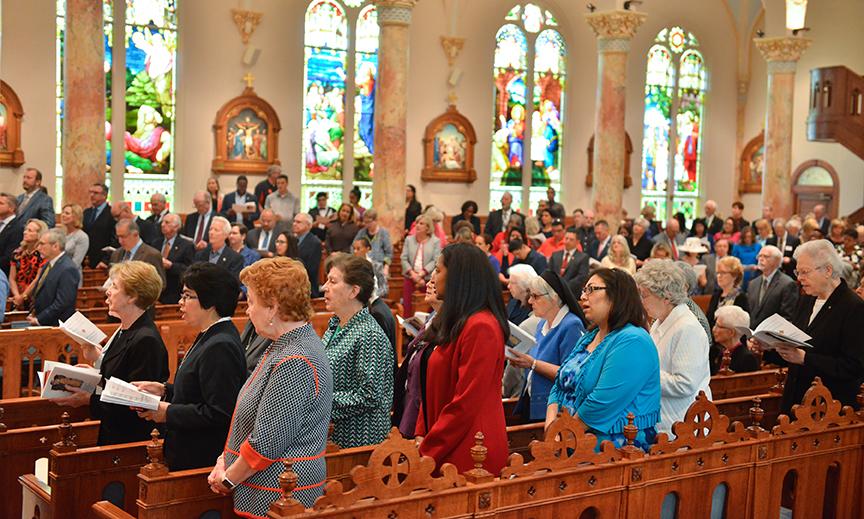 Attendees of the Eucharistic Celebration gathered in pews