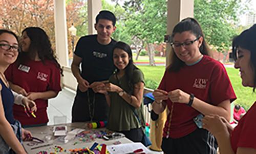 1ecec136-f7b3-4de6-957a-8a7af0c5bf1e.jpg Volunteers making beaded necklaces