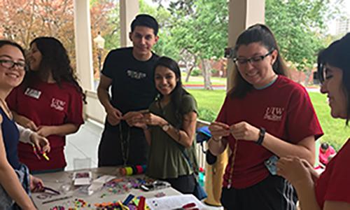 Volunteers making beaded necklaces