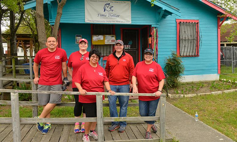 Group of volunteers pose in front of a store