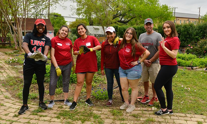 A group of volunteers in front of a garden