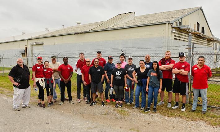 Group of volunteers pose in front of a building