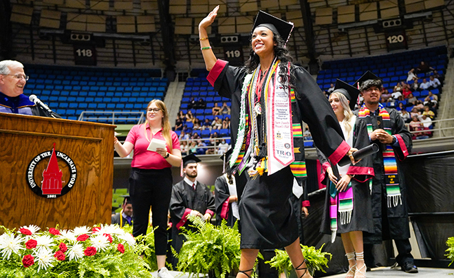 UIW graduate waving on stage