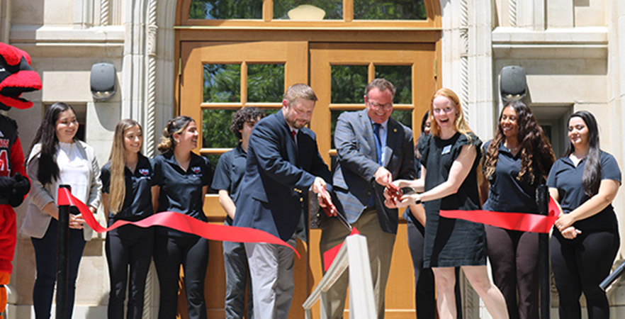 President Evans, Dr. Chris Summerlin, students and Red the Cardinal cut the ribbon at Dubuis Hall