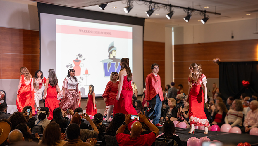 Multiple models on stage at Red Dress Fashion Show