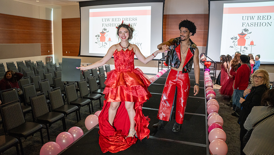 Two models on stage at Red Dress Fashion Show