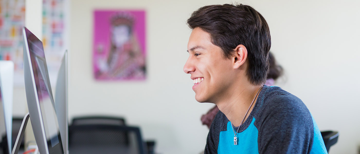 Close up from the side of student at his Mac workstation during class