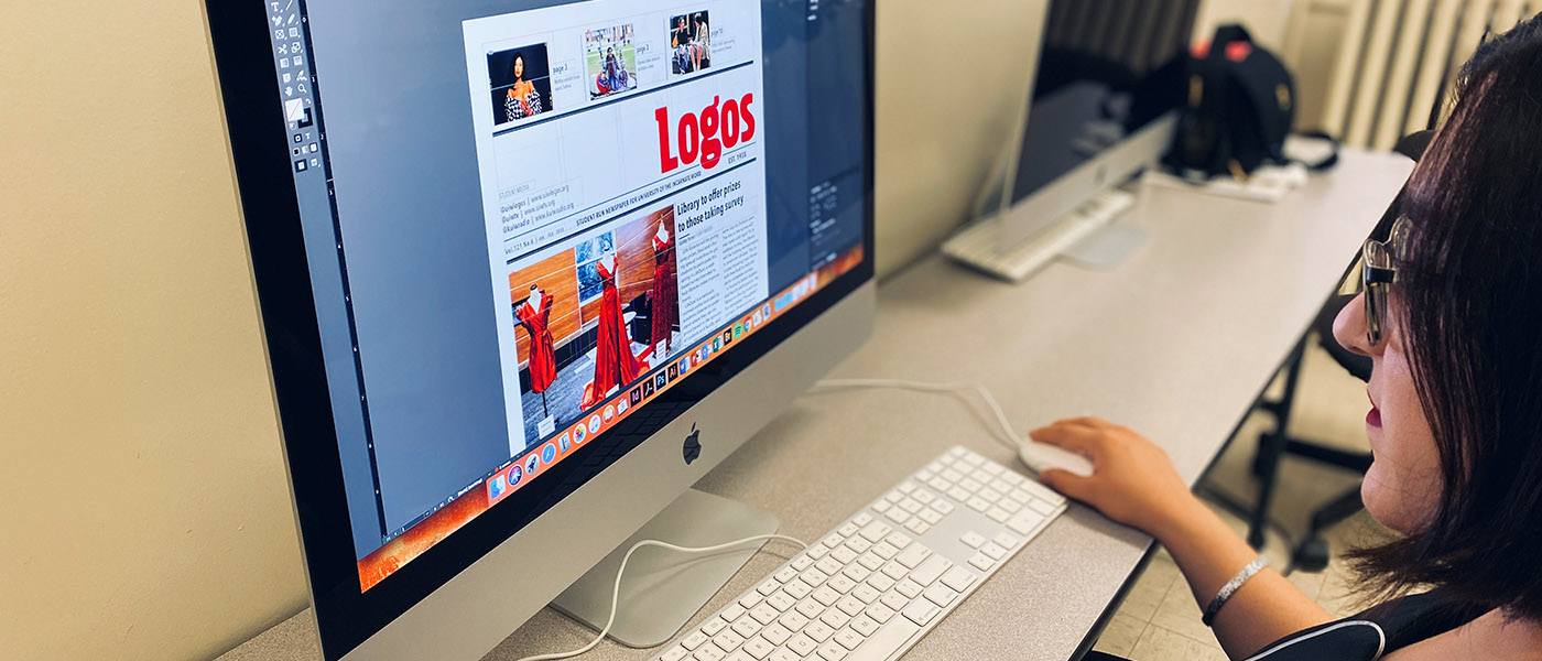Student working on her computer laying out a Logos newspaper issue