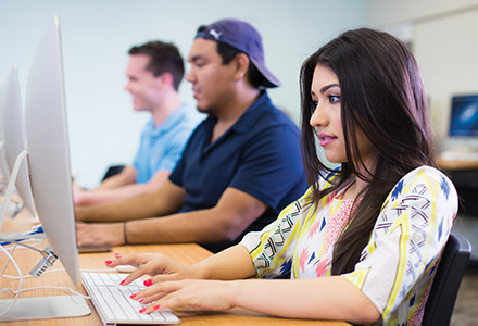 Close up of media and design students sitting in a computer lab for class