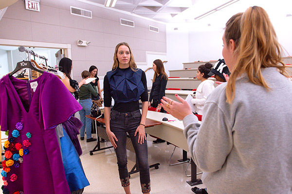 Group of design students looking over a design book during a club meeting