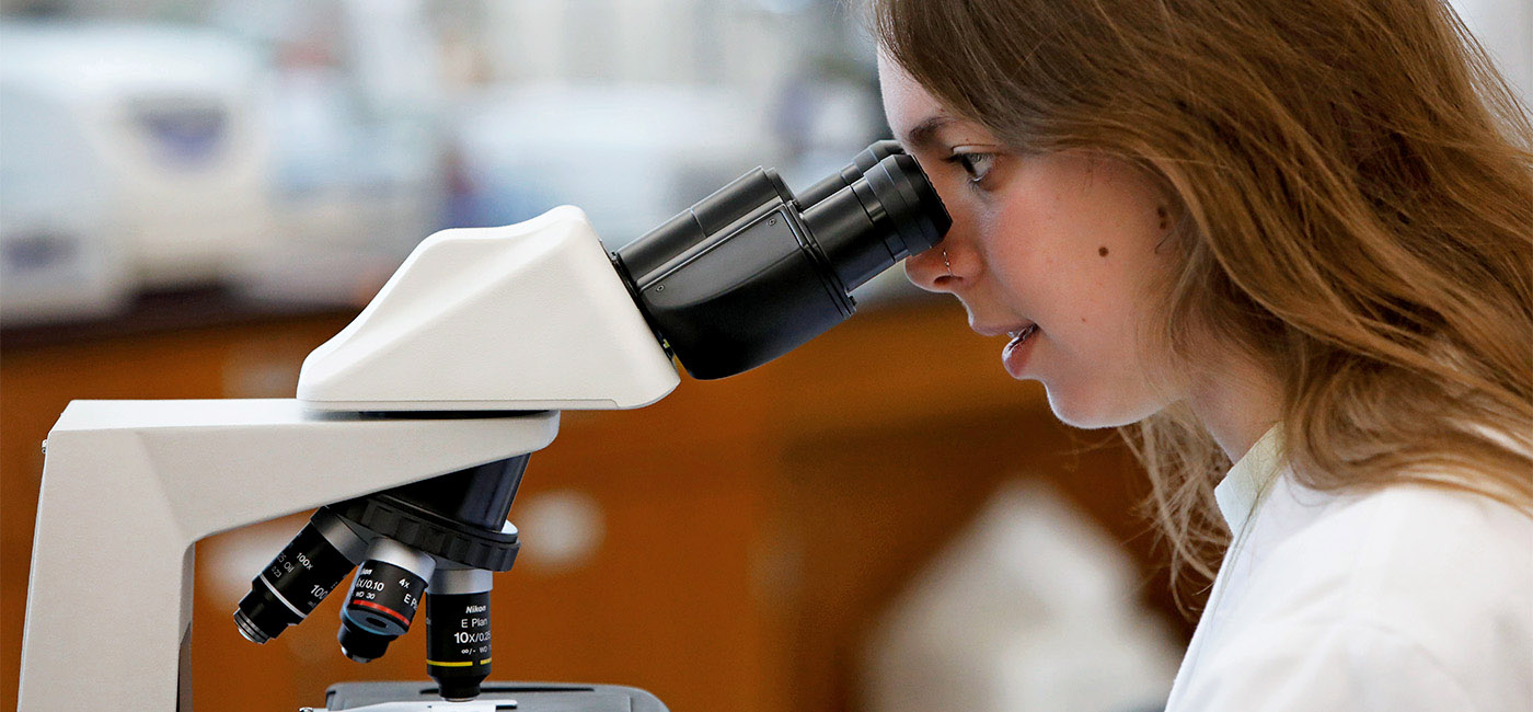 Female Student looking through Microscope