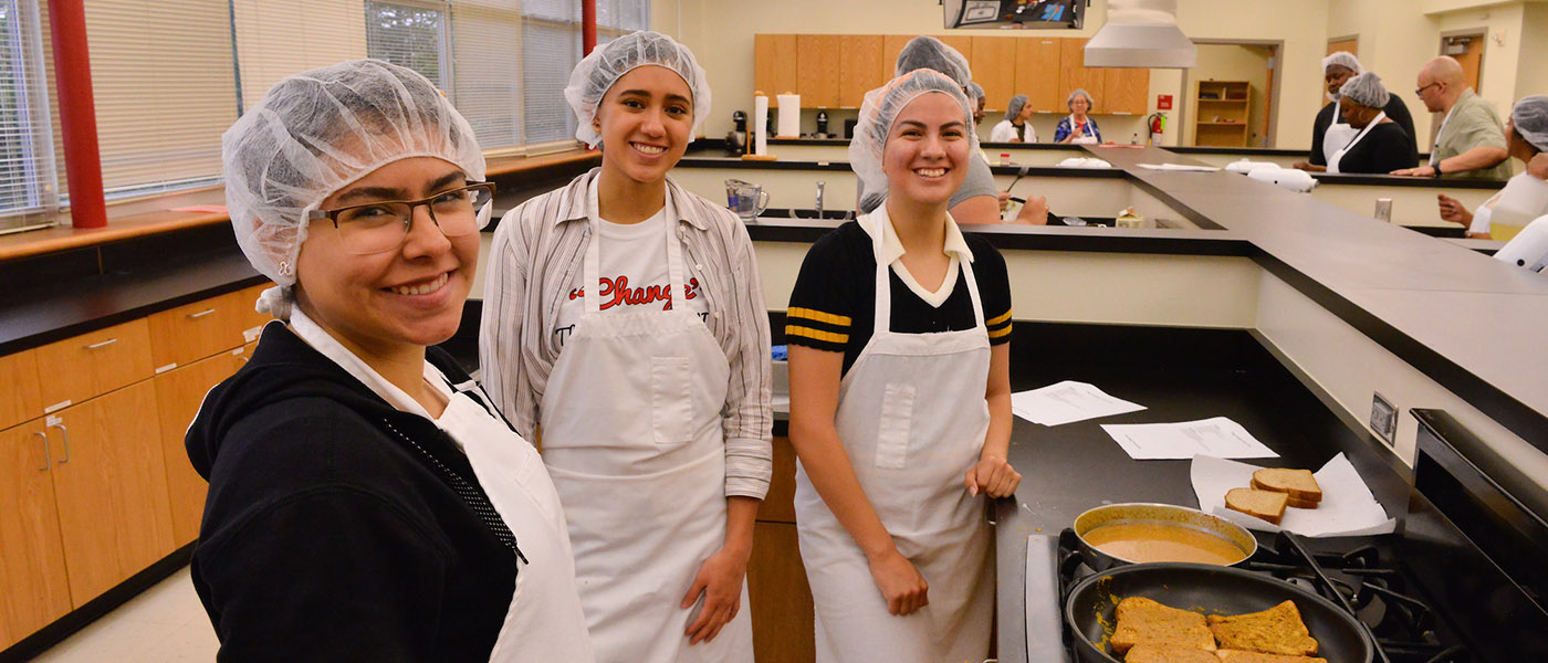 Students in a kitchen classroom preparing food