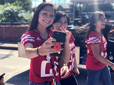 picture of two female students posing for selfie during Flight of th Cardinals walk through tailgate