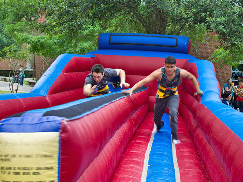 Students competing on an inflatable bungie cord race course