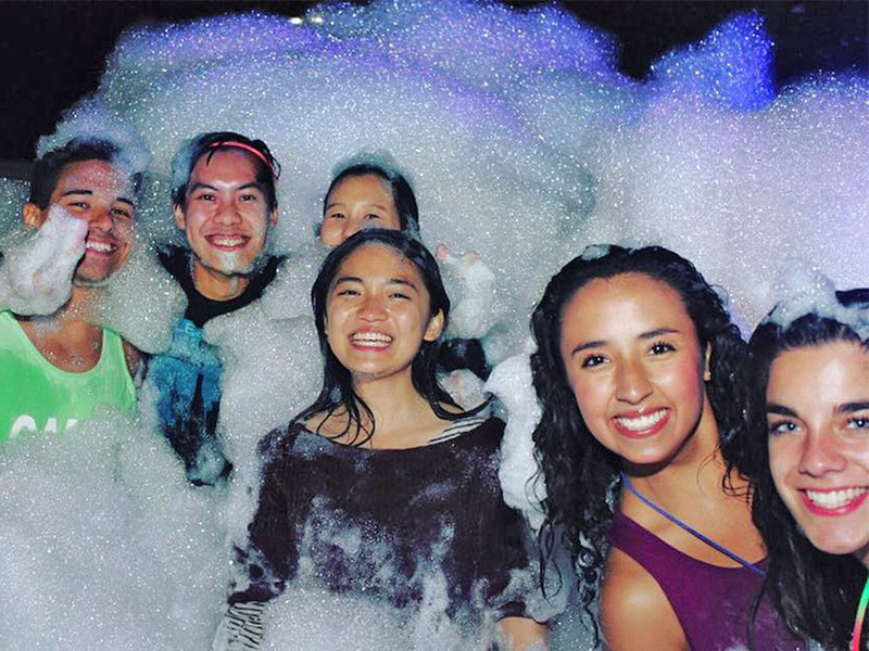 Students covered in foam during a foam party